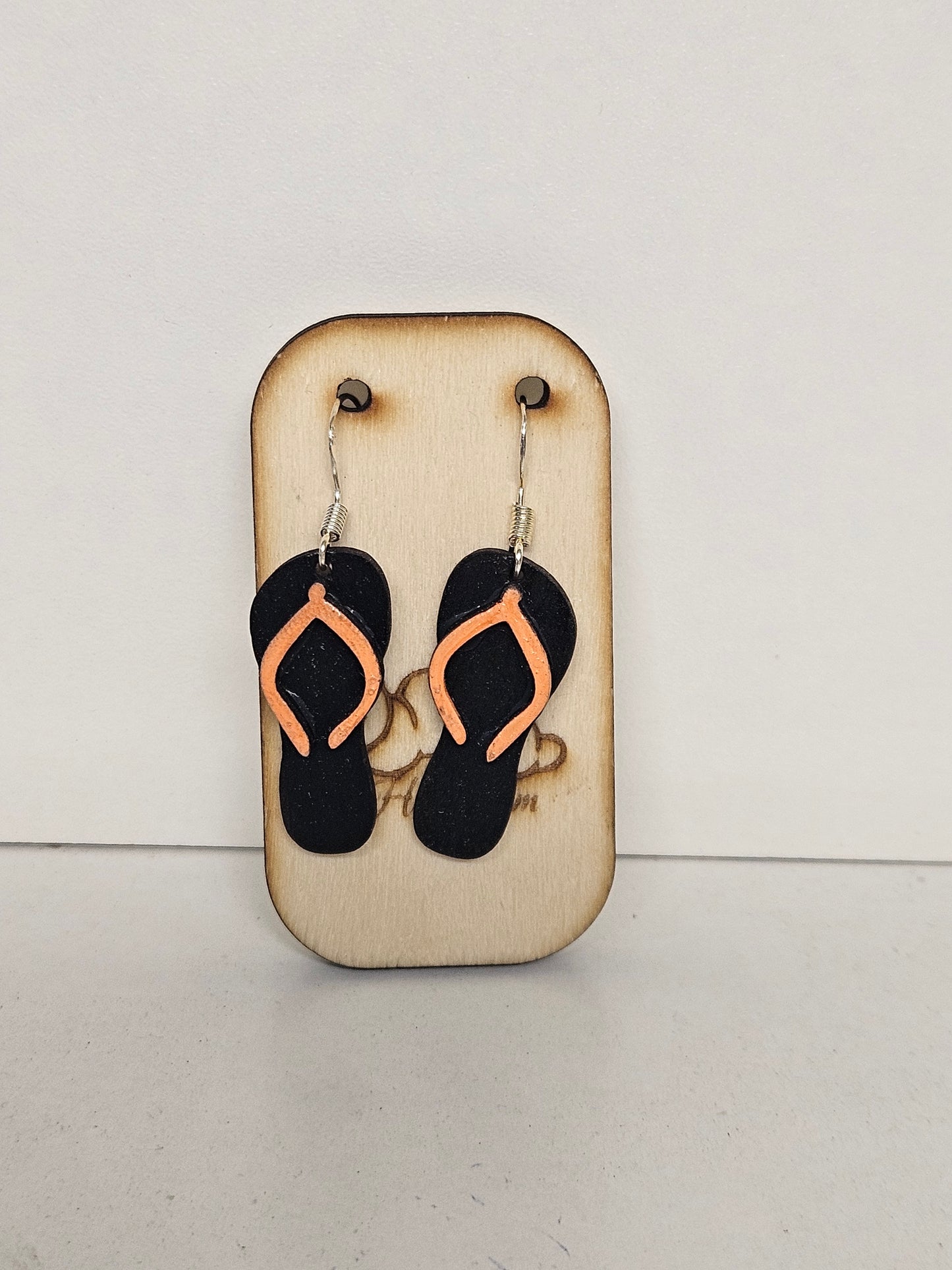 Handgemachte Holz-Ohrringe Flip-Flop Schwarz mit Pfirsich-Riemchen und 925 Silberhaken auf Holzdisplay