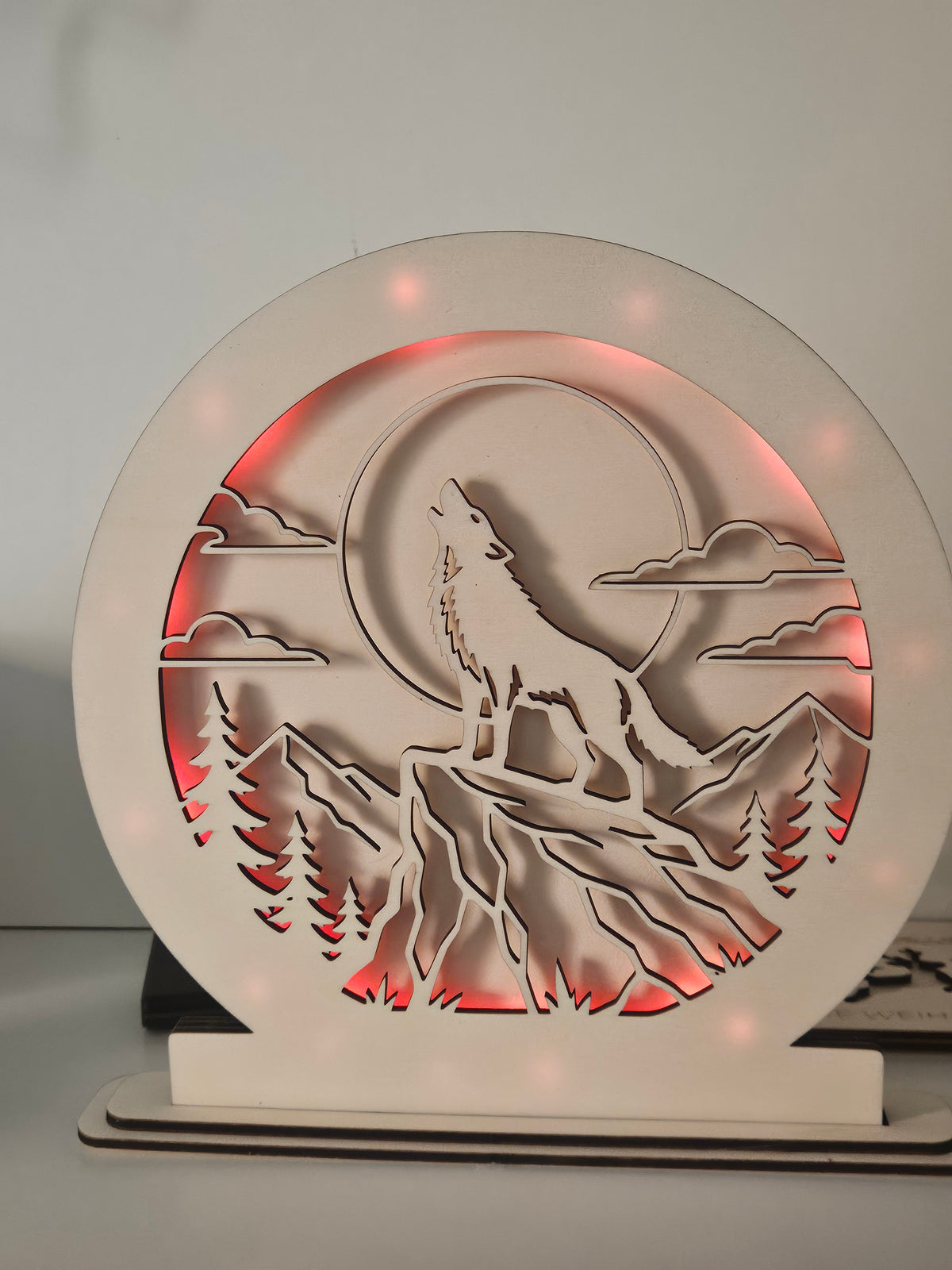 Runde LED-Lampe mit heulendem Wolf vor Mond und Berglandschaft, rot beleuchtet