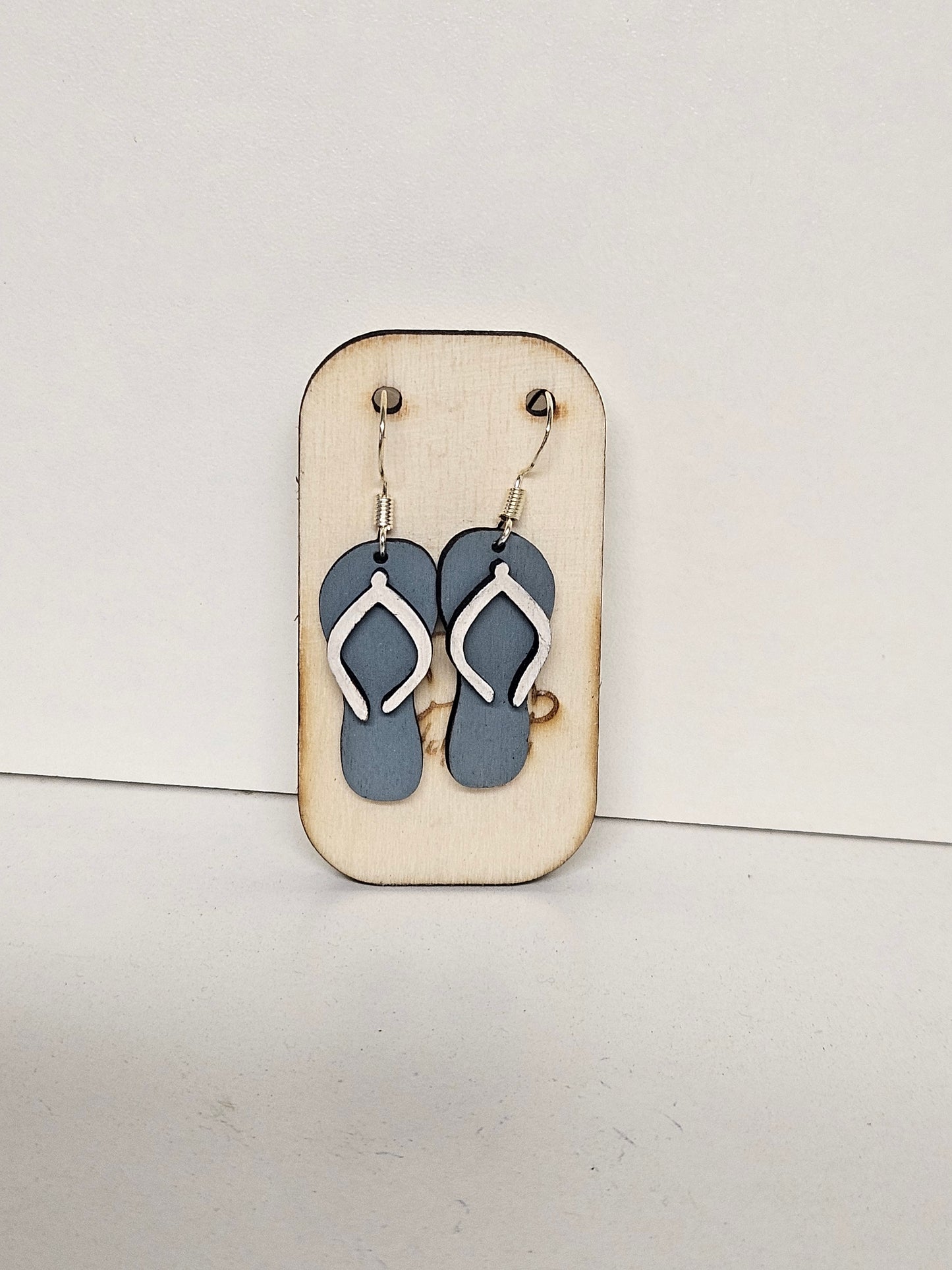 Handgemachte Holz-Ohrringe Flip-Flop Grau-Blau mit weißen Riemchen auf Holzdisplay