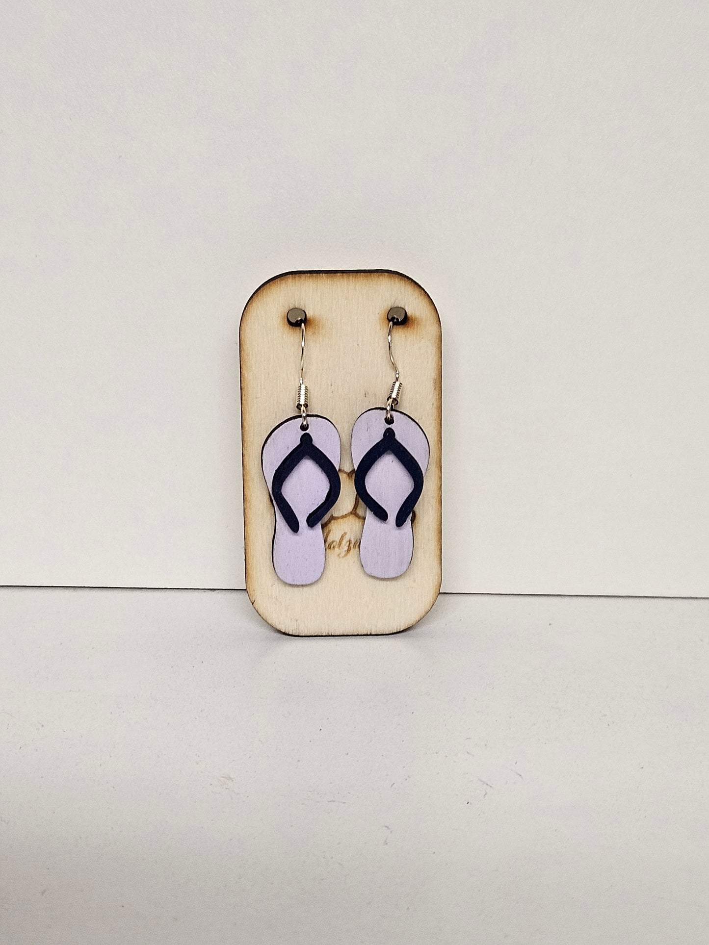 Handgemachte Holz-Ohrringe Flip-Flop Lila mit dunklen Riemchen auf Holzdisplay