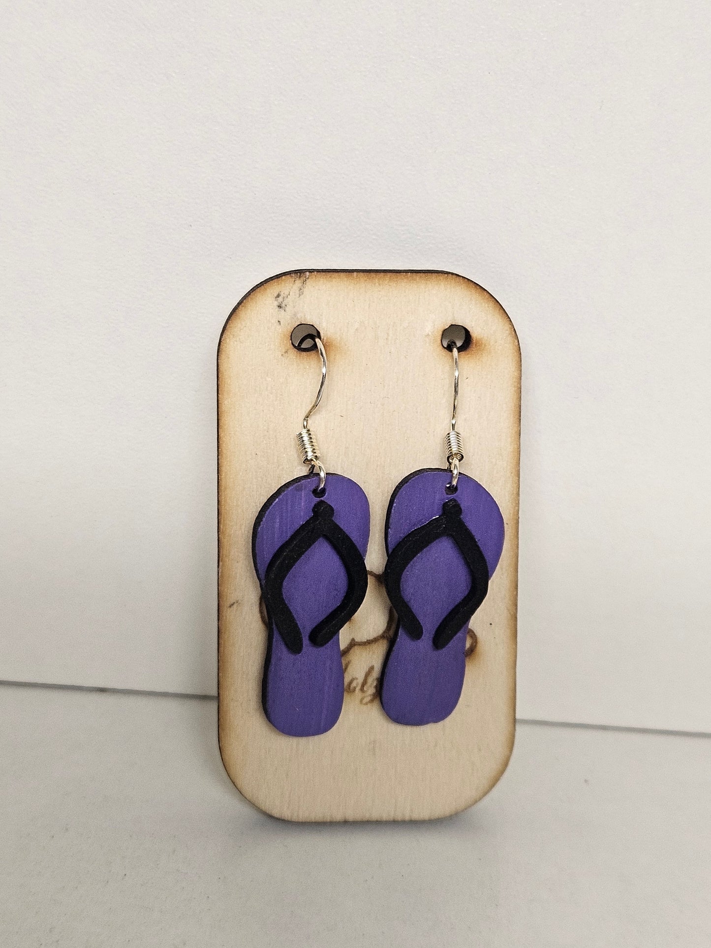 Handgemachte Holz-Ohrringe Flip-Flop Periwinkle Lila mit schwarzen Riemchen und 925 Silberhaken auf Holzdisplay