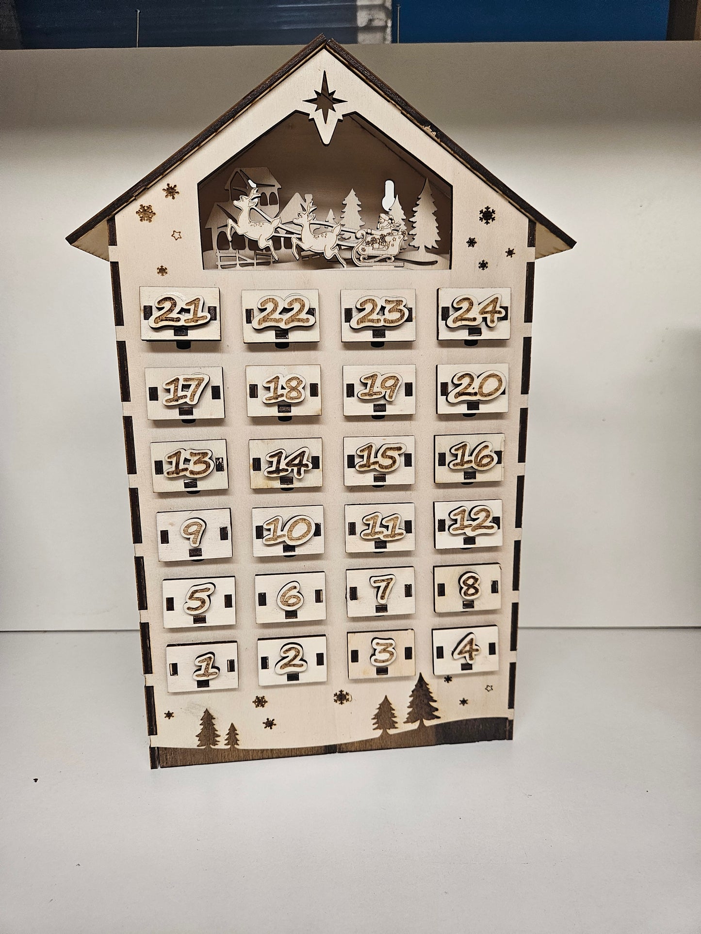 Adventskalender Holzhaus mit 24 nummerierten Schubladen und Weihnachtsmann-Gravur