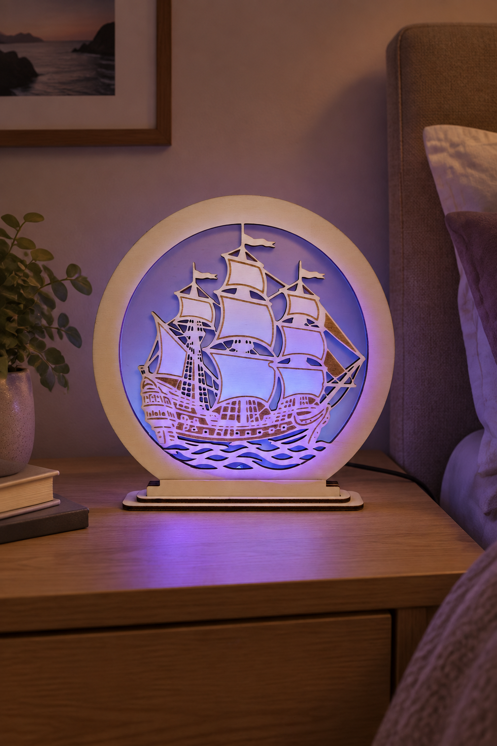 RGB-Holzlampe mit Segelschiff auf einem Nachttisch bei blau-violettem Licht
